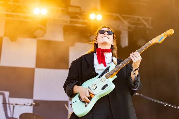 Paula Carolina spielt lächelnd eine hellblaue E-Gitarre auf der Main Stage des Bautz-Festivals.