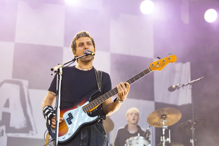 Ein Musiker spielt eine E-Bass-Gitarre und singt in ein Mikrofon auf der Main Stage des Bautz-Festivals.
