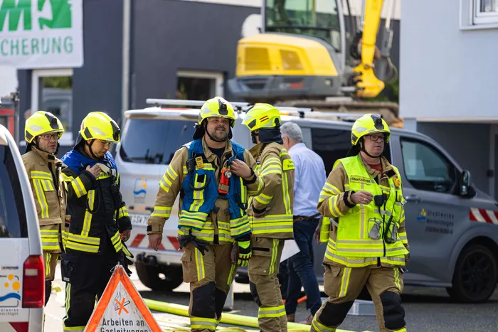 Firefighters carry an injured person away from a damaged gas line at a construction site in Meinerzhagen.