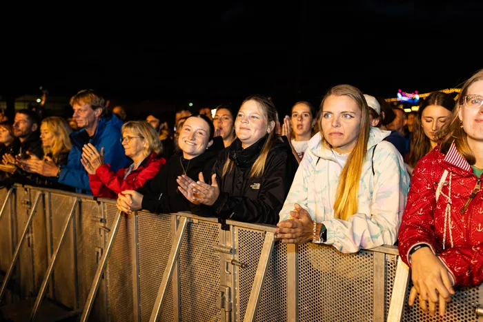 Zuschauer stehen nachts hinter einer Metallabsperrung beim Bautz Festival.