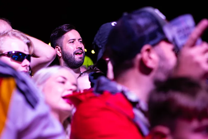 Ein bärtiger Mann blickt mit offenem Mund nach oben in einer Menschenmenge beim Bautz Festival.