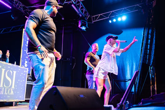 Isi Glück singt mit einem Mikrofon auf einer Bühne beim Bautz Festival 2026 unter blauem und violettem Licht.