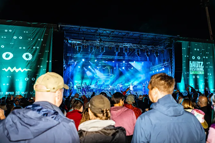Musiker auf einer blau beleuchteten Bühne beim Bautz-Festival 2026 vor einer Zuschauermenge im Nattenbergstadion.
