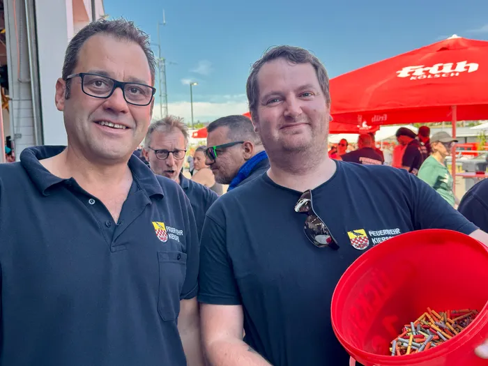 Zwei Männer in dunkelblauen Poloshirts mit dem Aufdruck 