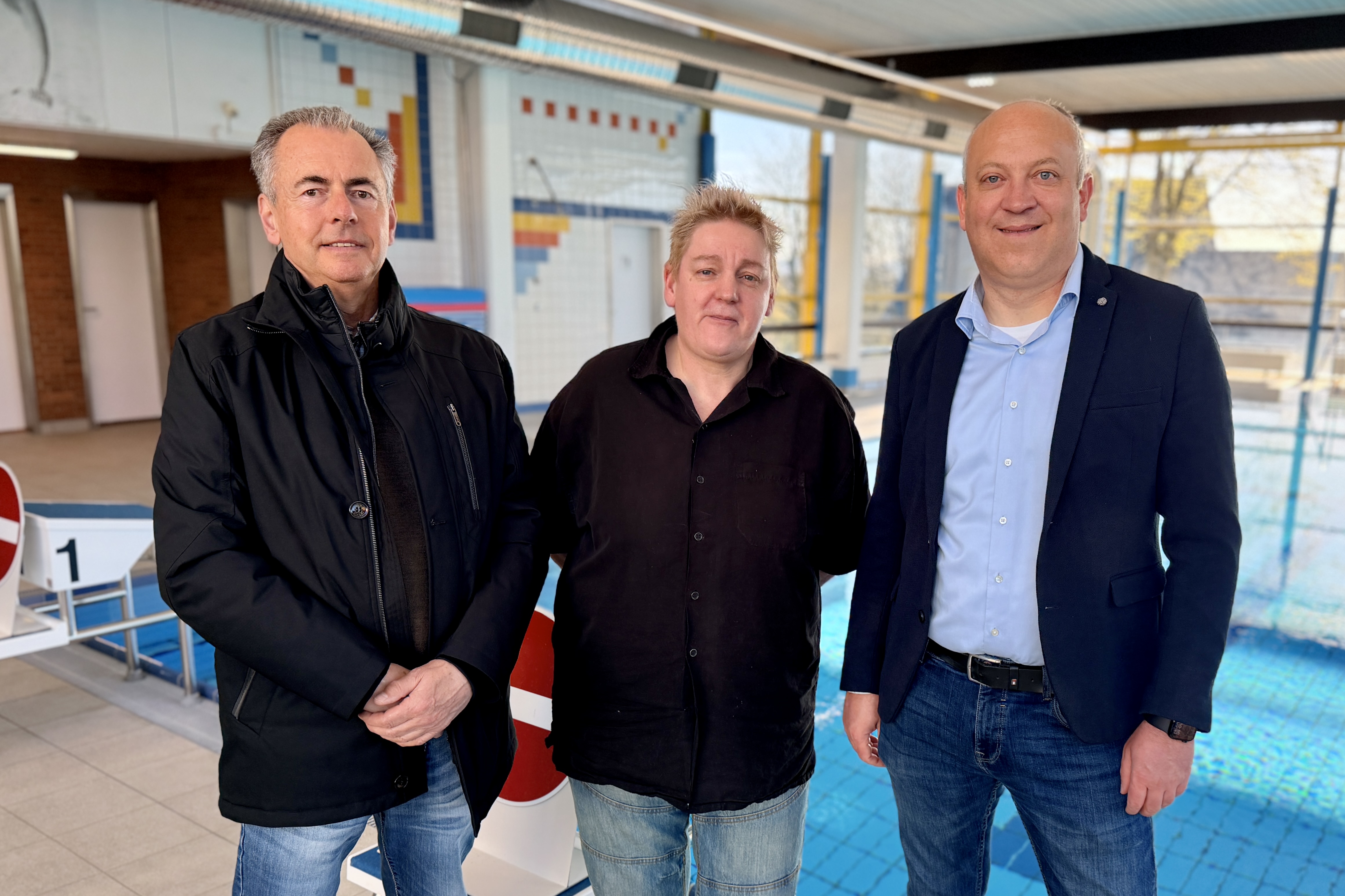 Drei Personen stehen nebeneinander vor einem Schwimmbecken: Jürgen Seuthe, Bettina Maciejewski und Bürgermeister André Dahlhaus.