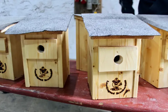 Vogelhäuser aus Holz mit Schindeldach und dem Logo der Breckerfelder Landjugend.