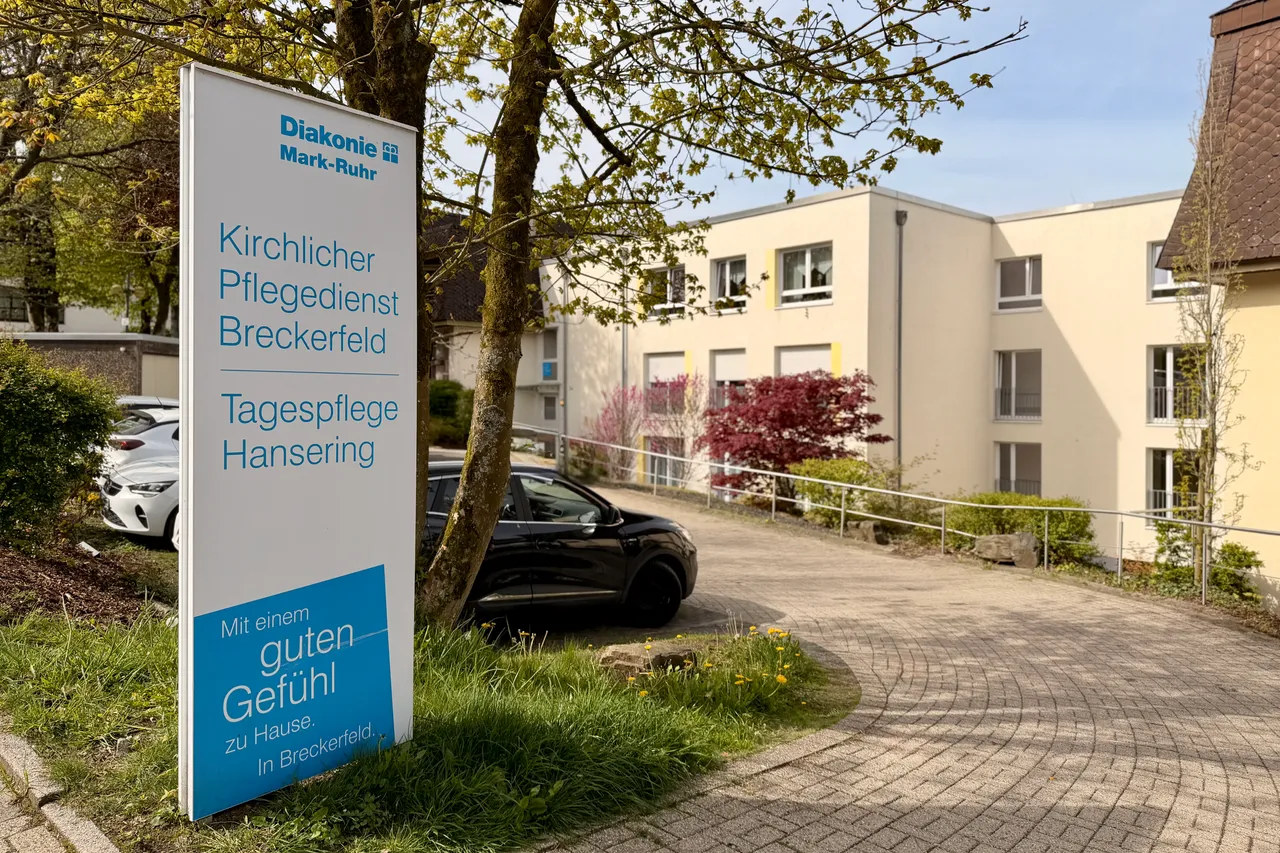 Schild des Kirchlichen Pflegedienstes Breckerfeld und der Tagespflege Hansering vor einem hellen Gebäude mit gepflegtem Vorgarten.