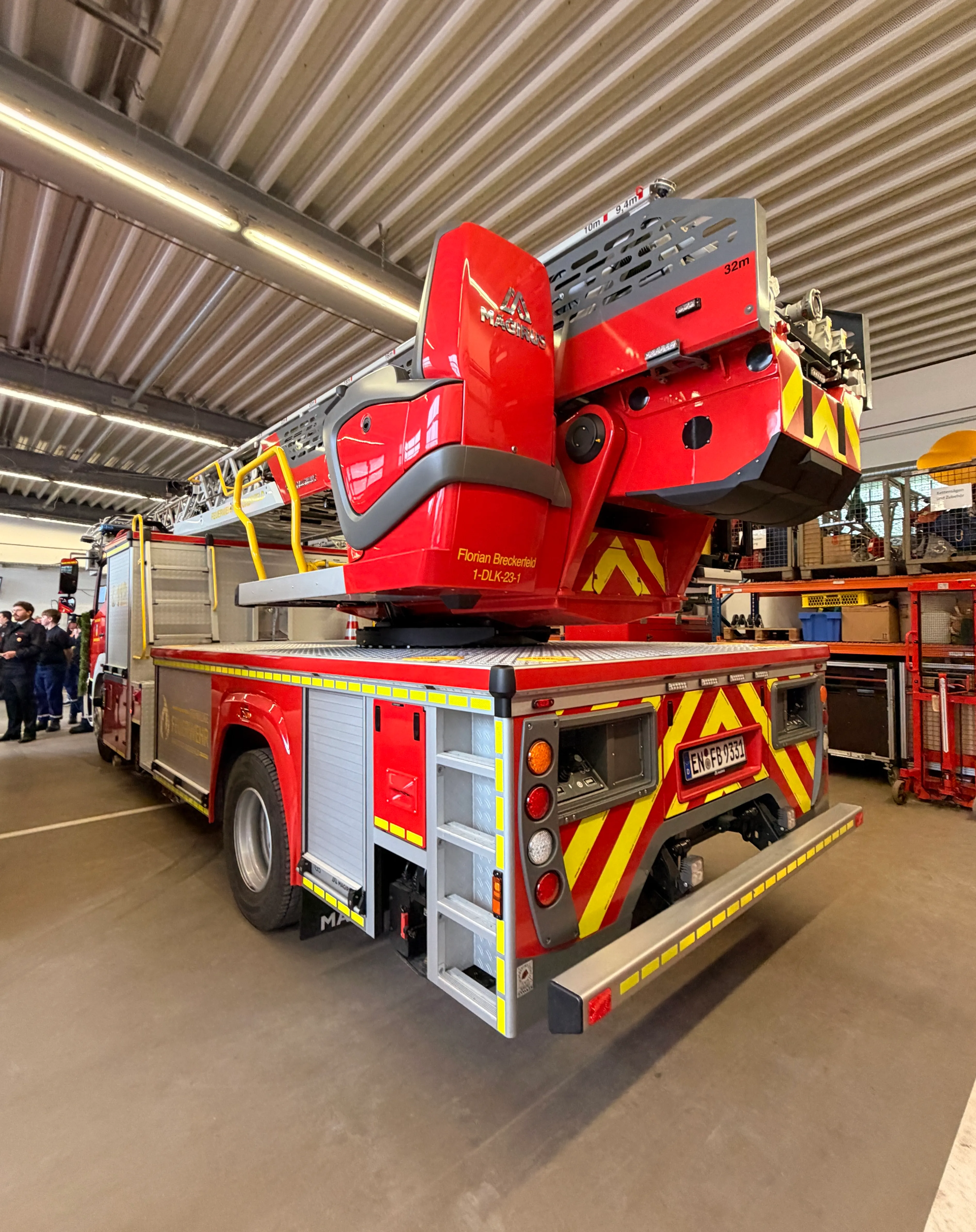Rotes Feuerwehrauto mit ausgefahrenem Teleskopmast in einer Werkshalle, Kennzeichen EN-FB 9331.