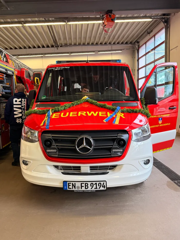 Weißer Mercedes-Sprinter der Freiwilligen Feuerwehr Anreppen mit Tannenzweig und Schleife als Dekoration, Kennzeichen EN-FB 2194.