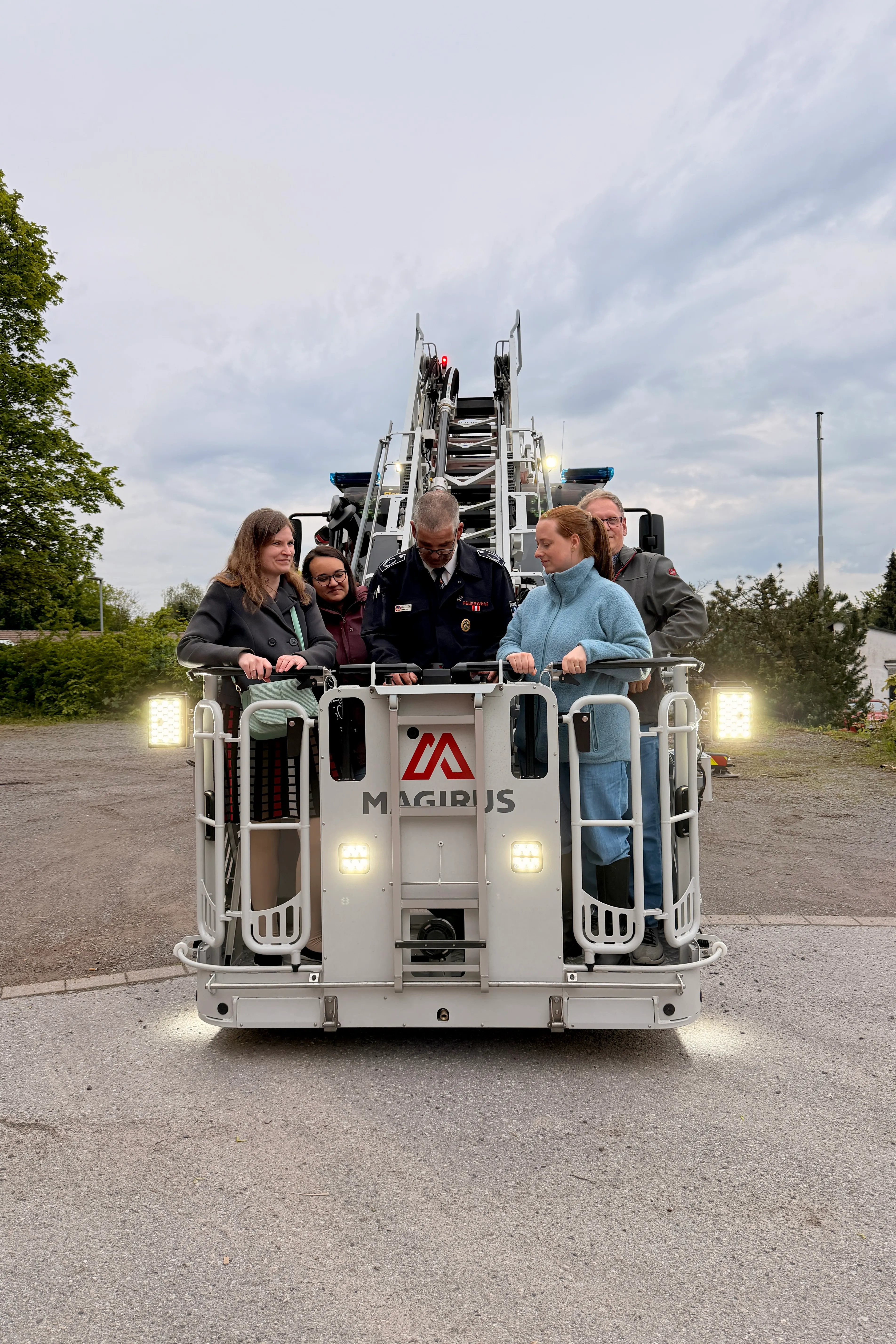 Mehrere Personen stehen vor einer neuen Drehleiter der Freiwilligen Feuerwehr Breckerfeld, die mit dem Schriftzug „Magirus“ versehen ist.