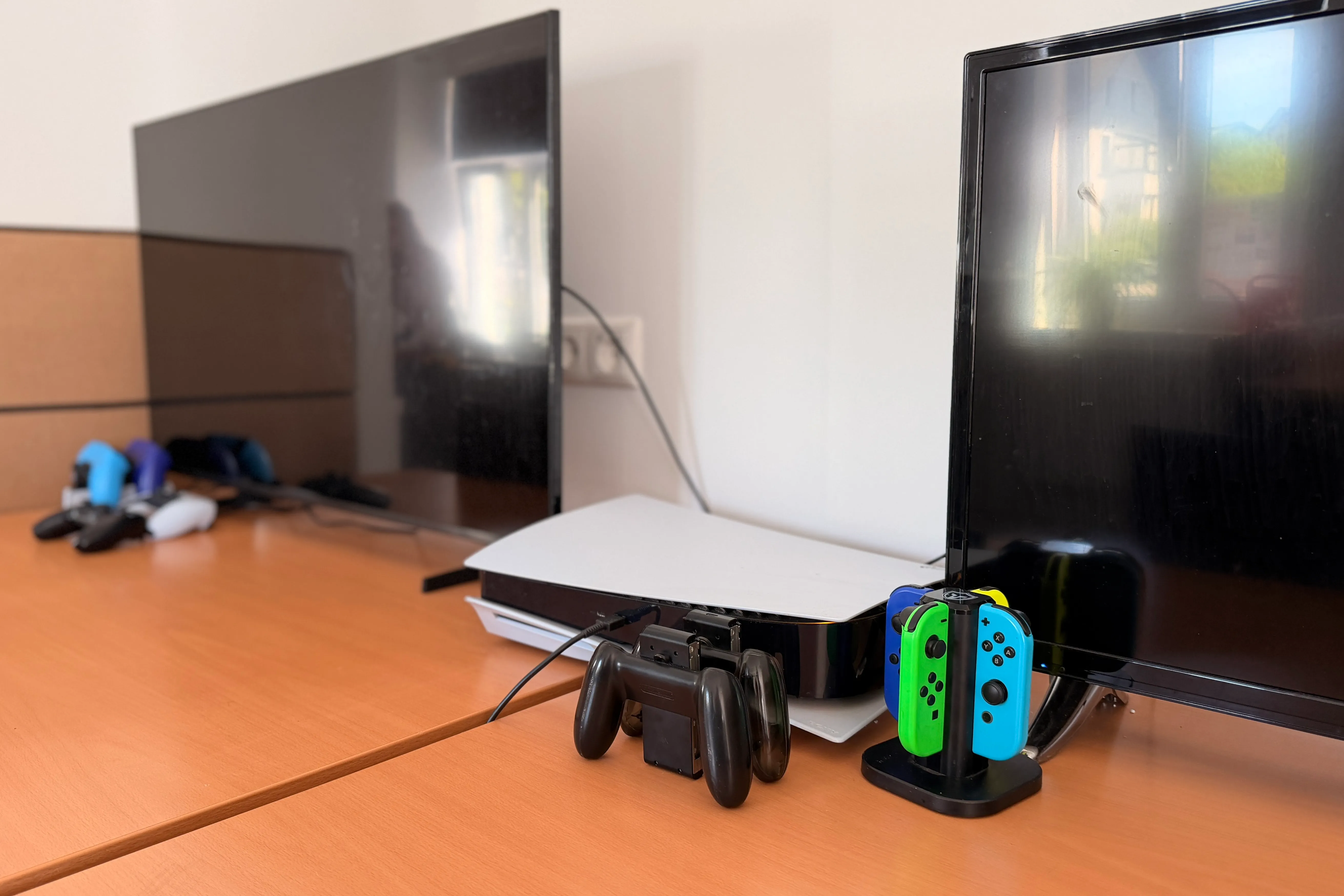Spielkonsole, Controller und Nintendo Switch stehen auf einem orangefarbenen Tisch vor einem Fernseher im Jugendzentrum Breckerfeld.