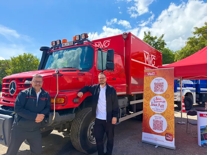 Zwei Männer stehen vor einem roten MVG-Lkw mit Aufschrift 