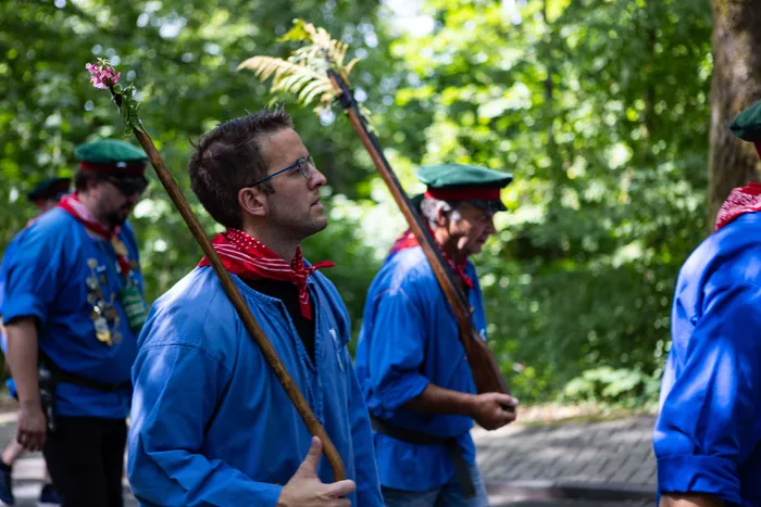 Schützen ziehen mit Gewehren und Fahnen durch einen Wald, der neue Prinz der Schützengilde Meinerzhagen wurde geschossen.