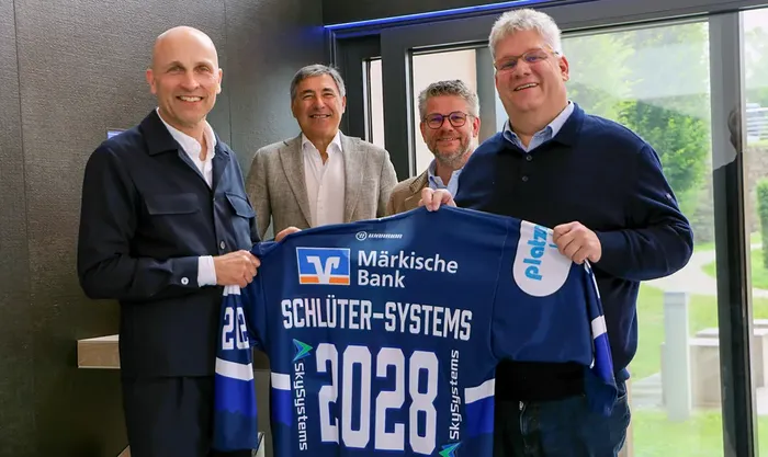 Vier Männer halten ein Eishockeytrikot mit dem Aufdruck 'Schlüter-Systems 2028' und dem Logo der Märkischen Bank. Von links: Frank Richter, Wolfgang Brück, Marc und Udo Schlüter.