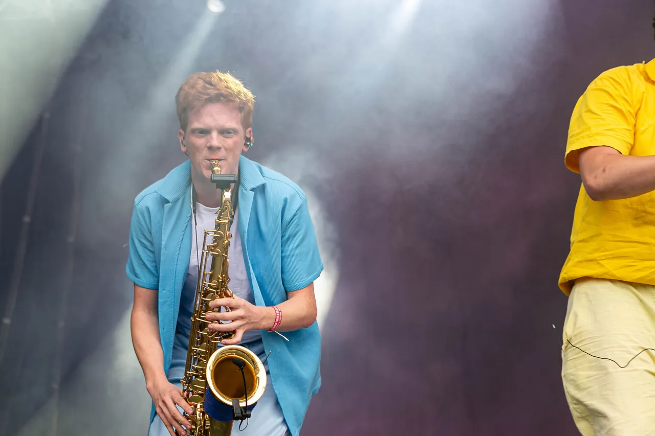 Ein Mann mit rötlichen Haaren spielt ein Saxophon auf einer Bühne mit Nebel beim Bautz Festival 2025.