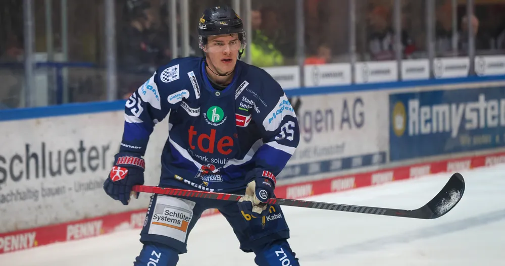 Eishockeyspieler Johannes Huss im blauen Trikot der Kassel Huskies mit Schläger auf dem Eis.