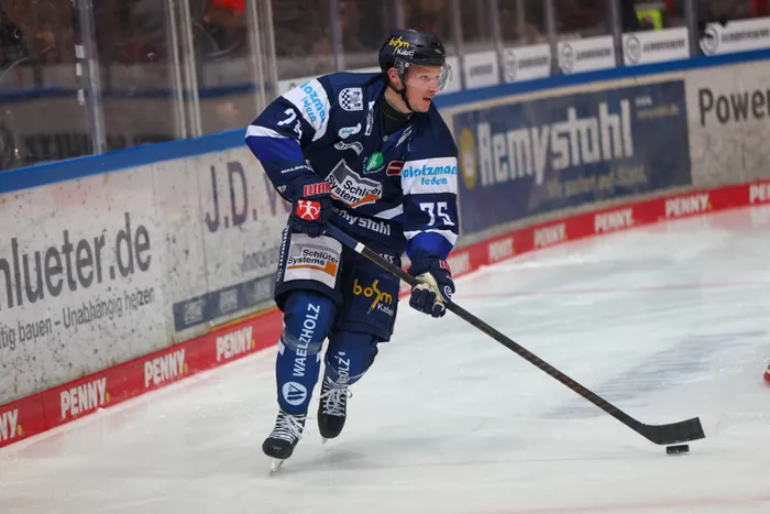 Julian Napravnik von den Iserlohn Roosters führt den Puck mit dem Eishockeyschläger über das Eis.