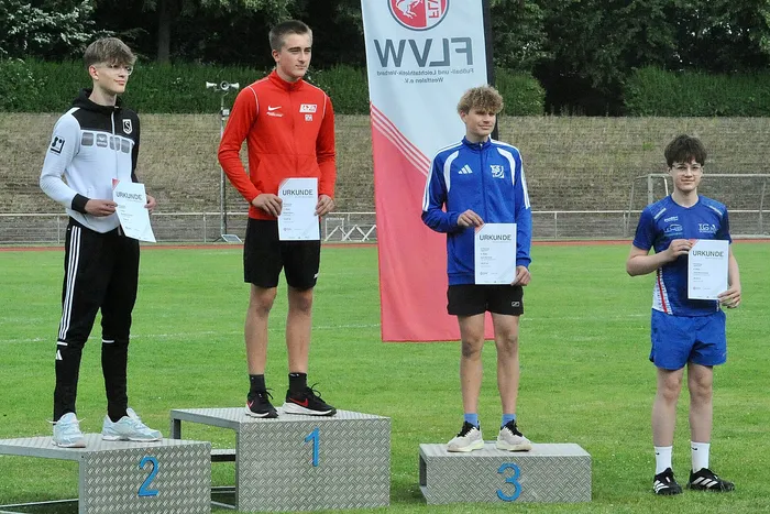 Vier junge Athleten stehen auf Podeststufen. Der Sieger steht auf der obersten Stufe, die anderen auf den Stufen darunter. Alle halten Urkunden in den Händen.