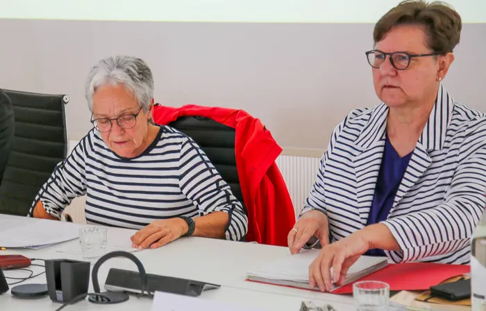 Jutta Heedfeld und Barbara Dienstel-Kümper sitzen an einem Tisch mit Unterlagen während einer Ausschusssitzung.