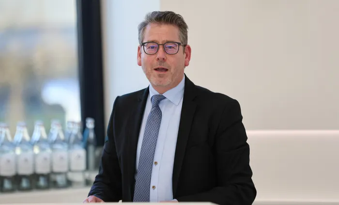 Karsten Meininghaus, CDU-Politiker mit Brille und Anzug, spricht in einer hellen Umgebung.