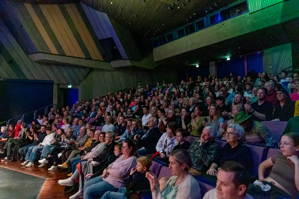 Volles Publikum in einem Theater bei der Premiere der Show „Kaskadia“, viele Menschen schauen auf die Bühne.