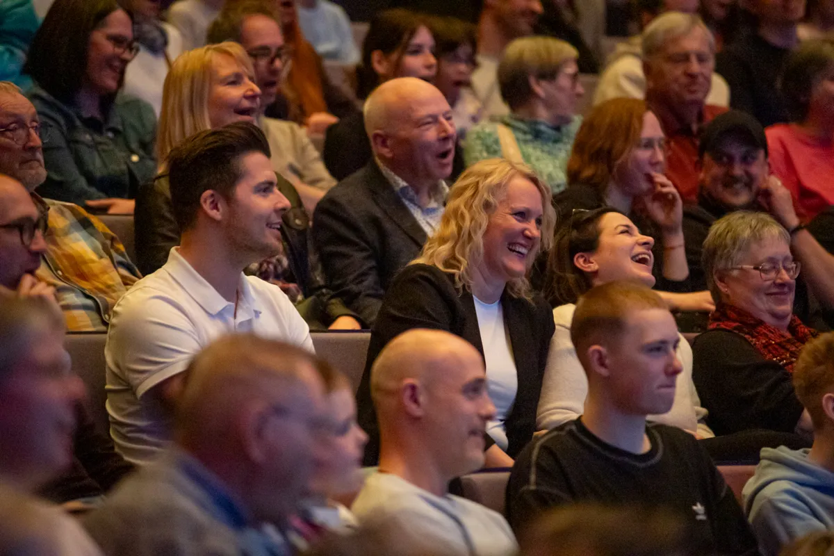 Zuschauer lachen und zeigen Freude während der Premiere der Show „Kaskadia“ im Publikum.