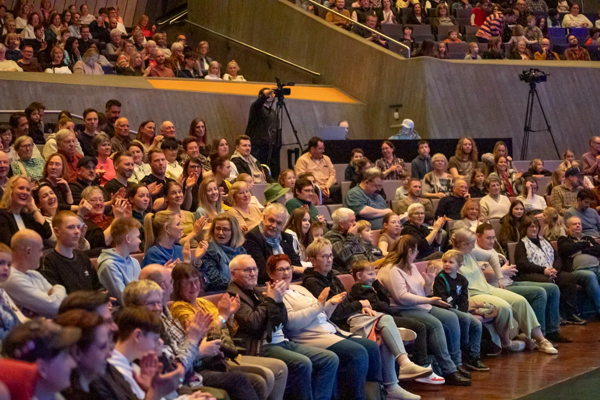 Zuschauer klatschen und lächeln während der Premiere der Show „Kaskadia“ in einem voll besetzten Saal.