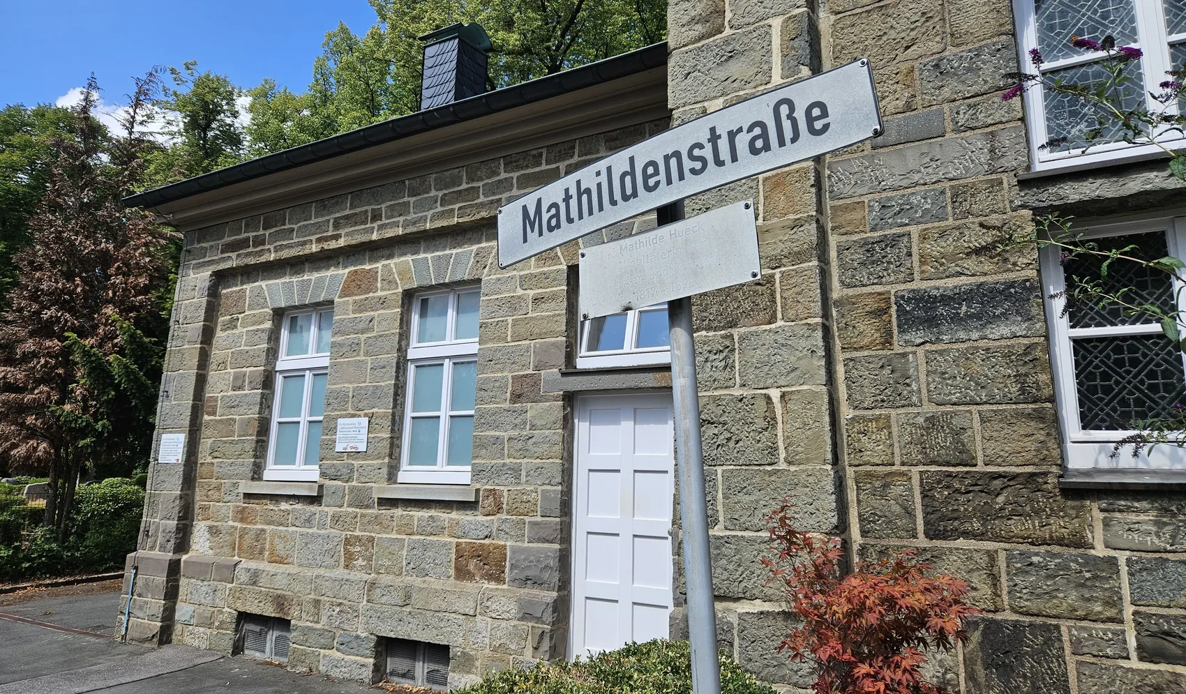 Straßenschild der Mathildenstraße vor einem Steingebäude.