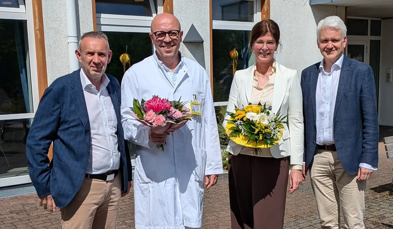 Vier Personen posieren im Freien vor einem Gebäude. Von links nach rechts: Stefan Herburg, Prof. Dr. Max Meyer-Marcotty mit Blumenstrauß, Dr. Monika Schwalenberg mit Blumenstrauß und Dr. Thorsten Kehe.