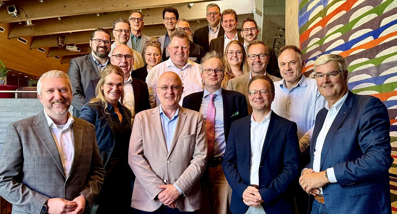 Eine Gruppe von Personen in Business-Kleidung posiert für ein Gruppenfoto bei einer Tagung im Lüdenscheider Kulturhaus.