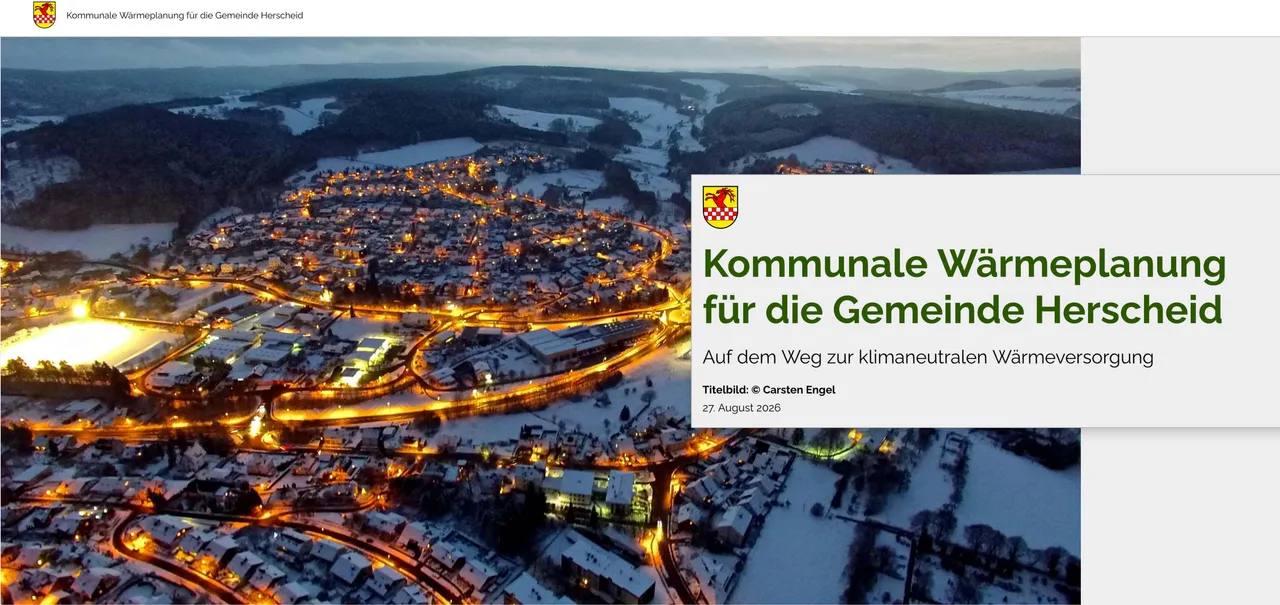 Luftaufnahme der verschneiten Gemeinde Herscheid bei Dämmerung mit beleuchteten Straßen und Häusern.