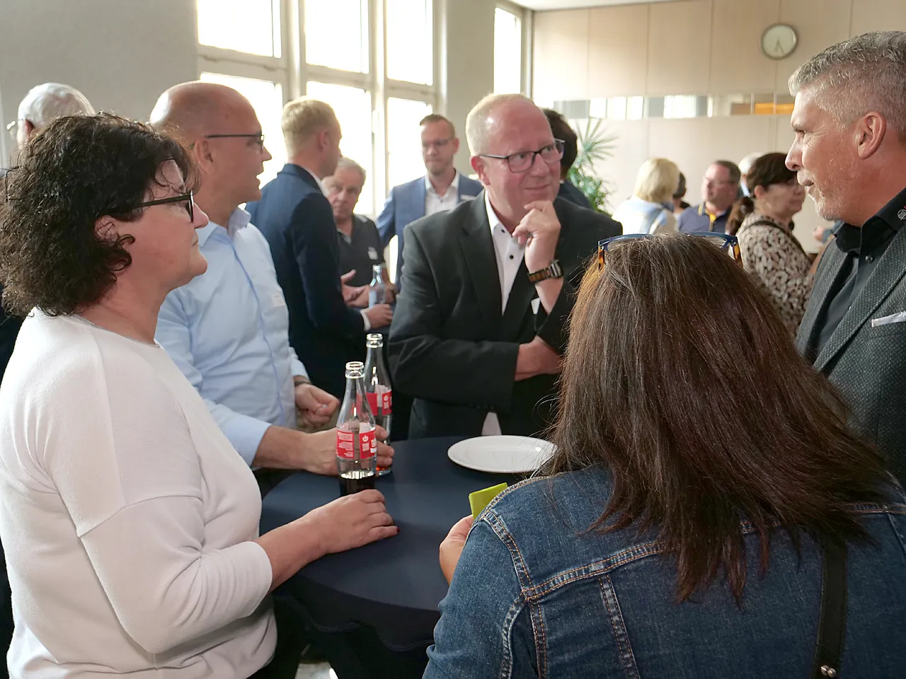 Teilnehmer des Wirtschaftsgesprächs in Plettenberg unterhalten sich in Gruppen an Stehtischen.