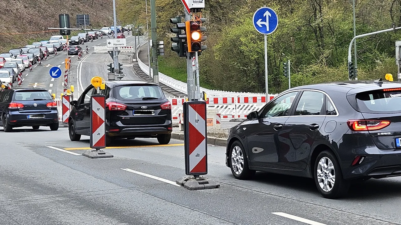 Stau auf der Straße vor dem Lennekreuz, während Bauarbeiten mit Leitplanken und Warnschildern im Hintergrund stattfinden.