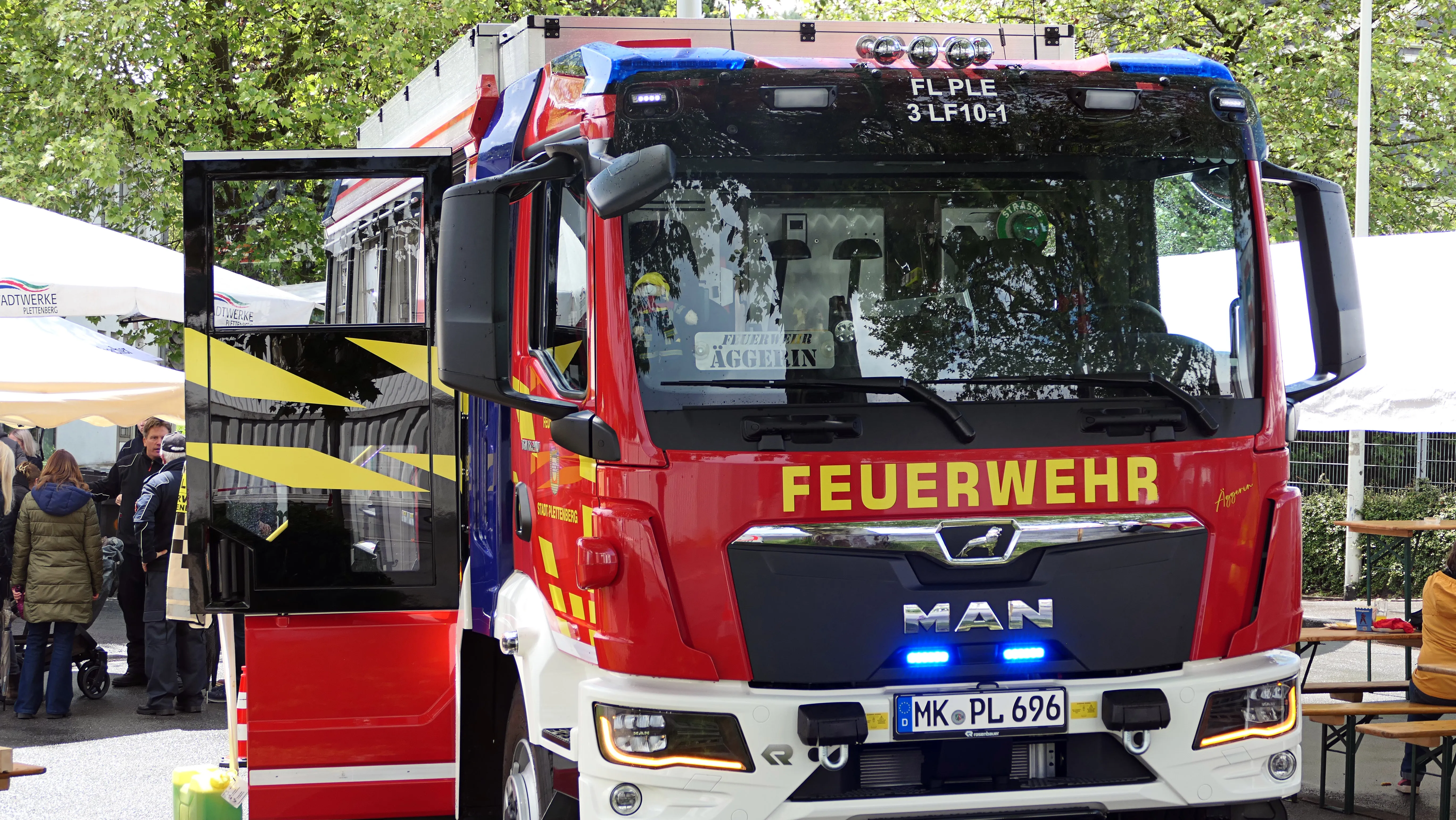 Roter und blauer Feuerwehrauto der Löschgruppe Eiringhausen mit geöffneter Fahrertür und der Aufschrift „FEUERWEHR“ am Kühlergrill.