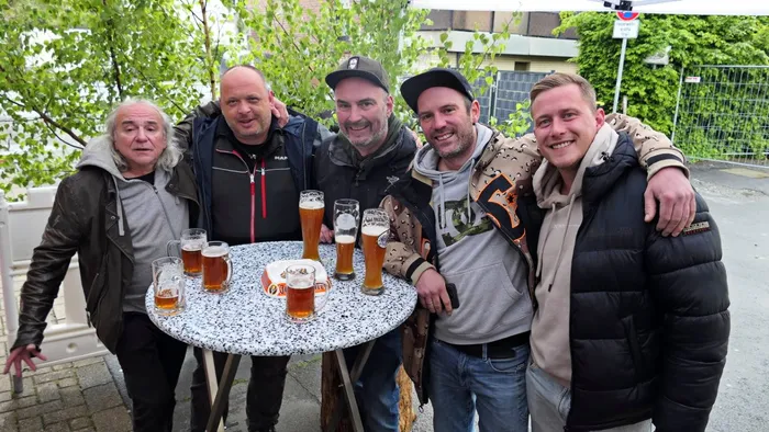 Fünf Männer stehen lächelnd um einen mit Biergläsern gefüllten Tisch im Freien, vermutlich bei einer Vatertagsfeier der Löschgruppe Ohle vor dem alten Feuerwehrgerätehaus.