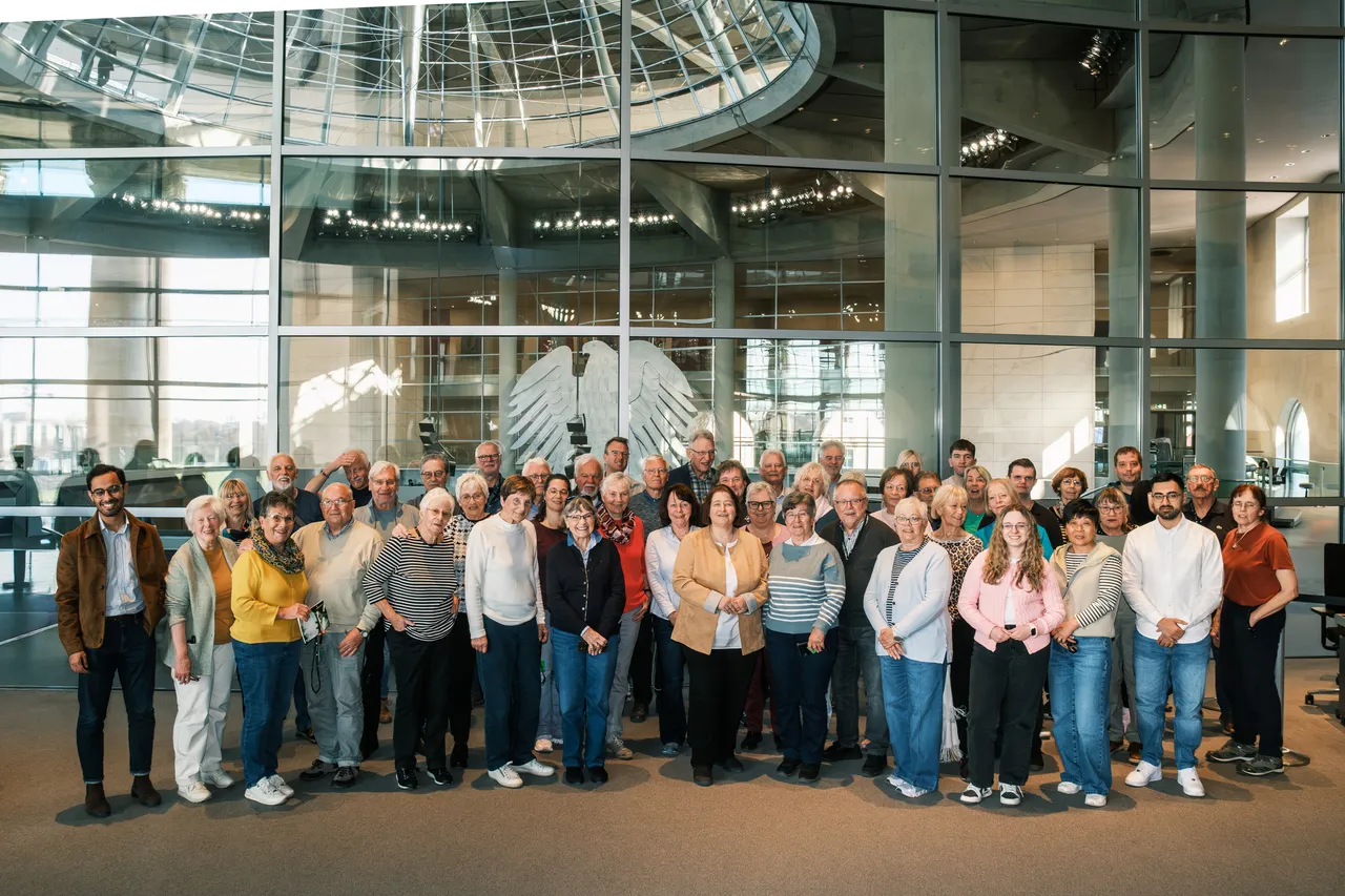 Eine Gruppe von etwa 40 Menschen steht vor einer großen Glasfassade mit dem Bundesadler im Hintergrund. Die Aufnahme entstand im Deutschen Bundestag während eines Besuchs aus dem Märkischen Kreis auf Einladung der Bundestagsabgeordneten Bettina Lugk.