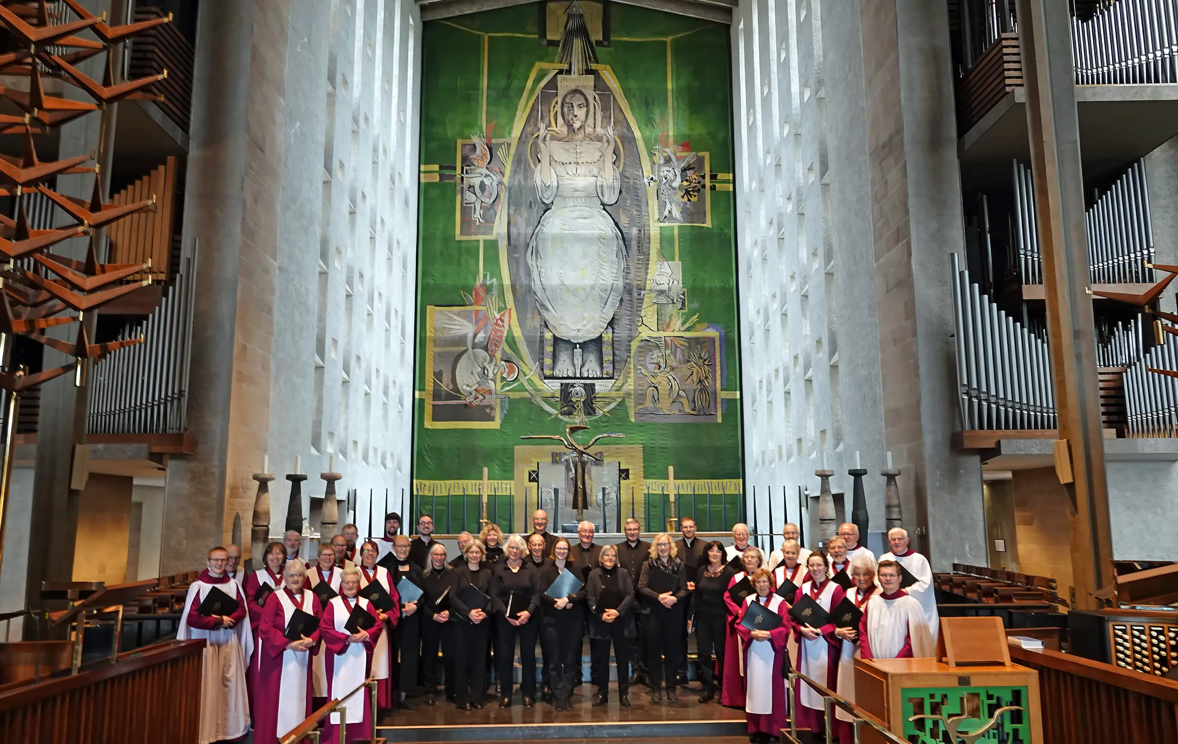 Chorvorstellung vor dem Altar einer Kathedrale mit einem großen, abstrakten Wandbild im Hintergrund.