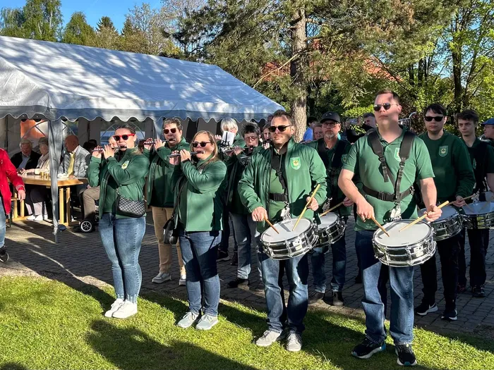 Musikzug der Landjugend und Kirchengemeinde Heedfeld spielt auf einem Maibaumfest mit Blasinstrumenten und Trommeln.