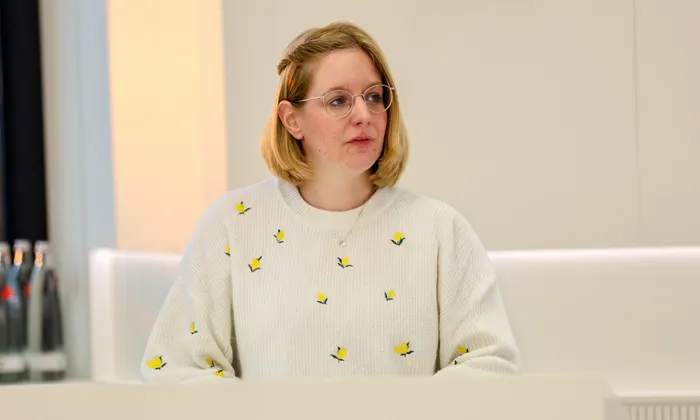 Marjan Eggers, Abgeordnete von Bündnis 90/Die Grünen, trägt einen weißen Pullover mit gelben Zitronenmustern und eine runde Brille.