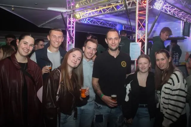 Eine Gruppe lächelnder junger Menschen mit Getränken beim Scheunenfest der Landjugend Hülscheid-Heedfeld.