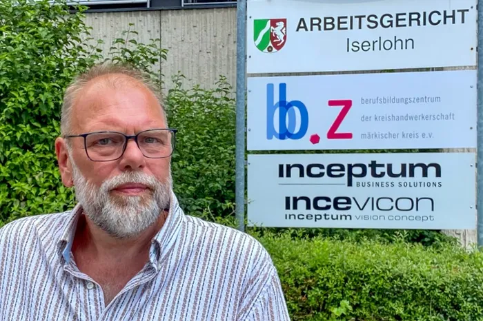 Olaf Loock steht vor dem Schild des Arbeitsgerichts Iserlohn.