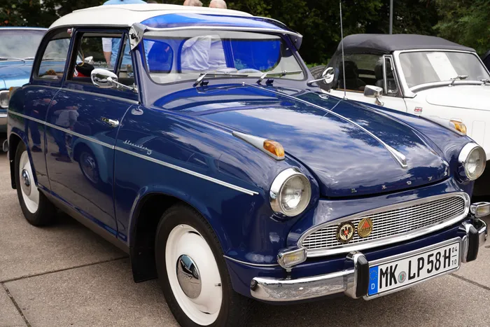 Ein blaues Oldtimer-Auto mit weißem Dach, weißen Felgen und Chromdetails.