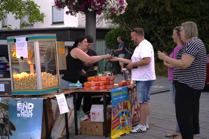 Ein Mann kauft Popcorn an einem Stand bei einem Open-Air-Kino.