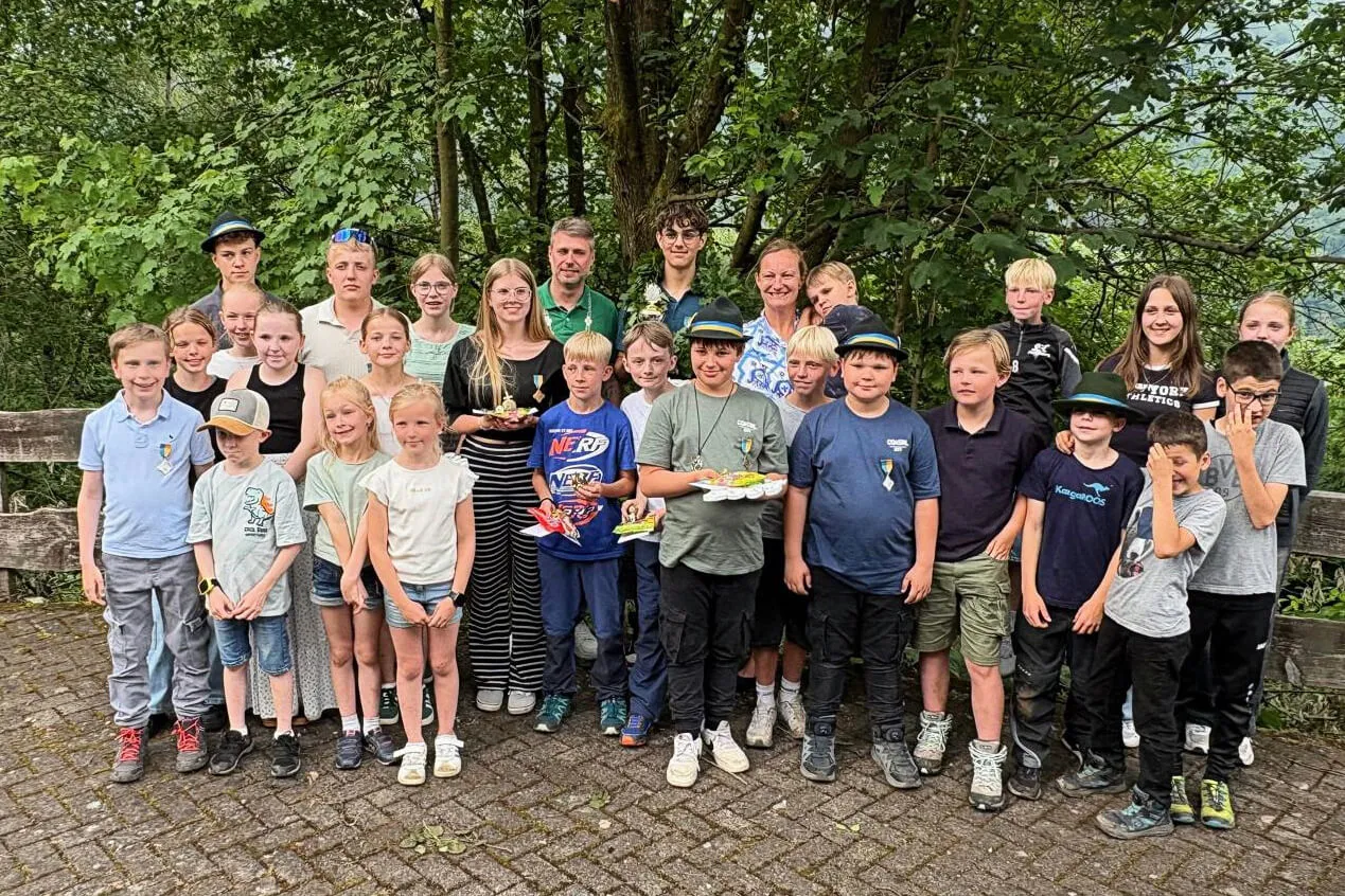 Eine Gruppe von etwa 30 Kindern und einigen Erwachsenen steht lächelnd für ein Gruppenfoto zusammen, nachdem sie am Kinderprobevogelschießen teilgenommen haben.