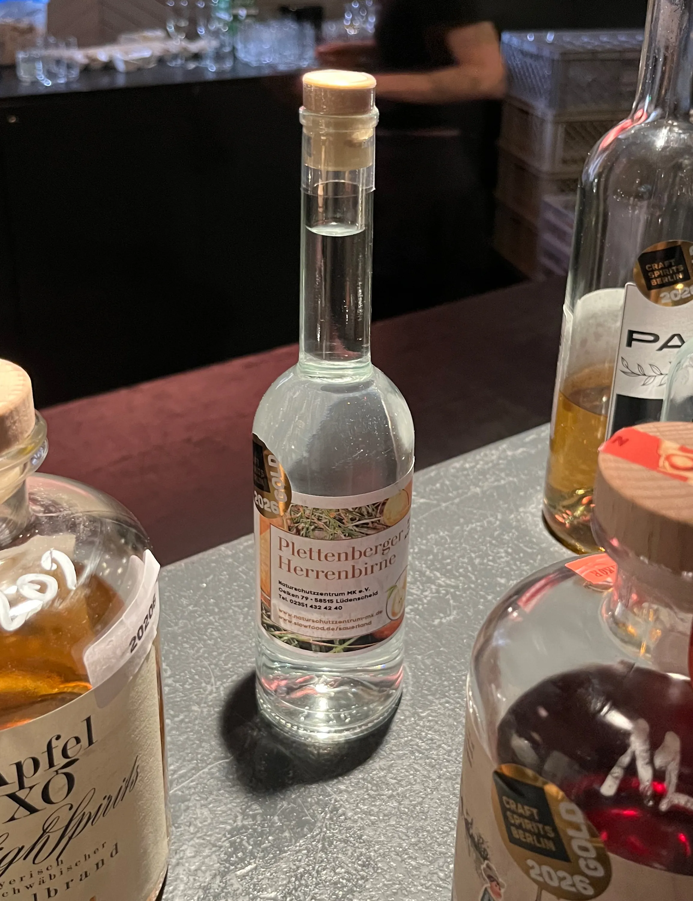 Eine Flasche Plettenberger Herrenbirne mit Gold-Auszeichnung beim Craft Spirits Award 2026 steht auf einem Holztisch.