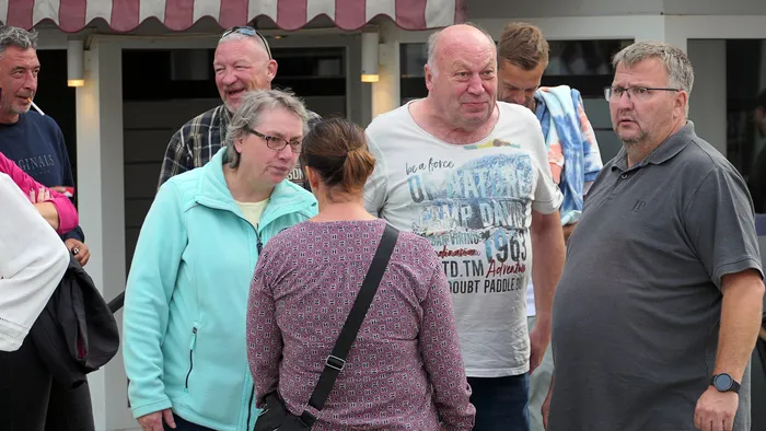Eine Gruppe von Menschen steht bei der Roxy Revival Party zusammen, darunter eine Frau in einer hellblauen Jacke und ein Mann in einem weißen T-Shirt.
