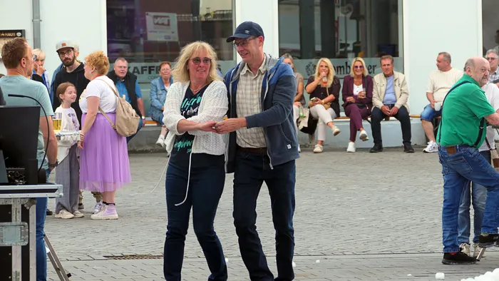 Ein Mann und eine Frau tanzen Hand in Hand bei der „Roxy Revival Party“ im Freien.