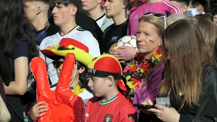 Fußballfans feiern bei einem Public Viewing auf der Elsewiese in Plettenberg den Sieg der deutschen Nationalmannschaft. Im Vordergrund ein Kind mit Sombrero und ein Fan mit Deutschlandfarben auf der Wange.