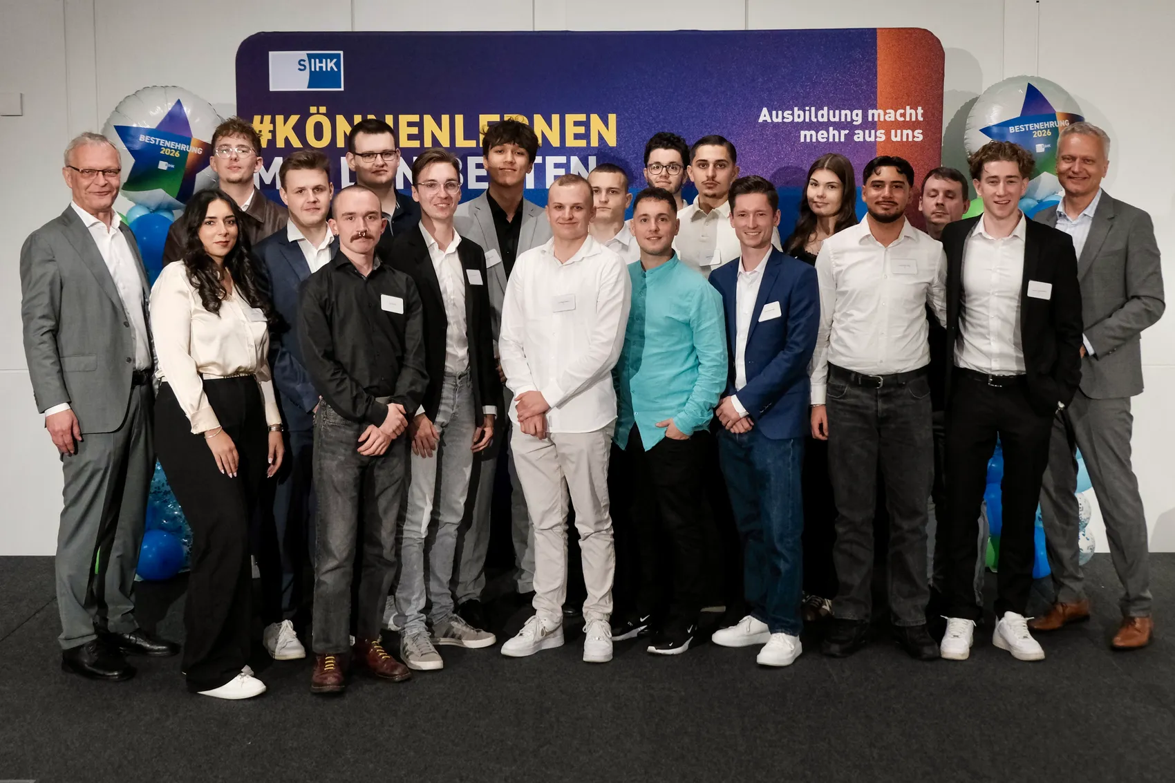Eine Gruppe von Auszubildenden und Vertretern des SIHK posiert für ein Gruppenfoto vor einem blauen Banner mit dem Schriftzug „#KÖNNENLERNEN“.