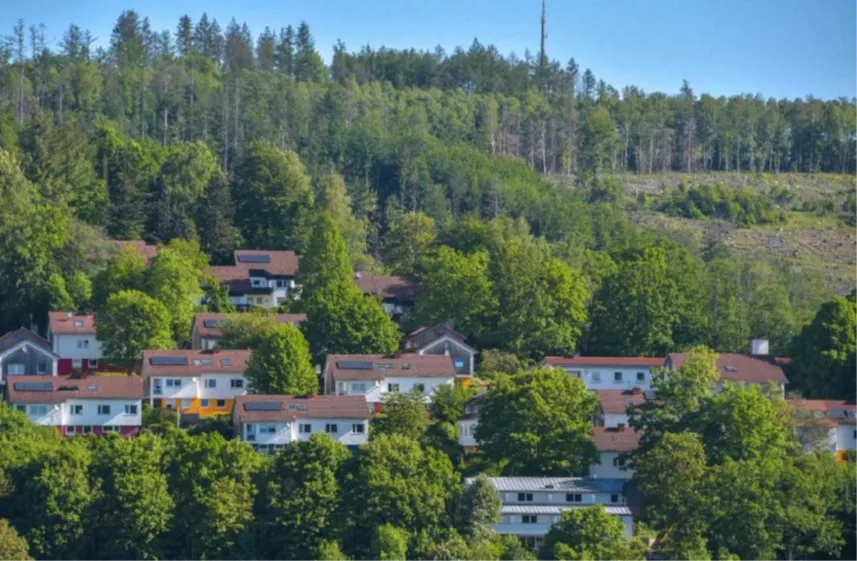 Das SOS-Kinderdorf Sauerland in Lüdenscheid-Gevelndorf erstreckt sich über eine Hügellandschaft mit vielen Bäumen und mehreren Wohnhäusern.